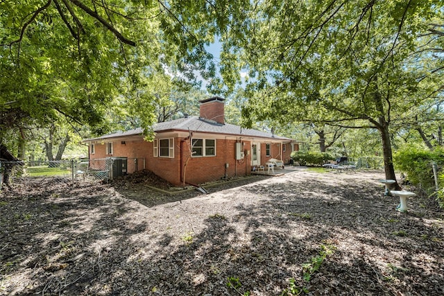 1719 W Day St, Denison, TX 75020 - view of home's exterior featuring brick siding, a chimney, a patio, and a gate