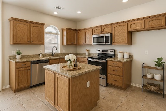 5901 Ozark Dr, Fort Worth, TX 76131 - kitchen featuring appliances with stainless steel finishes, a kitchen island, light stone countertops, light tile patterned floors, and recessed lighting