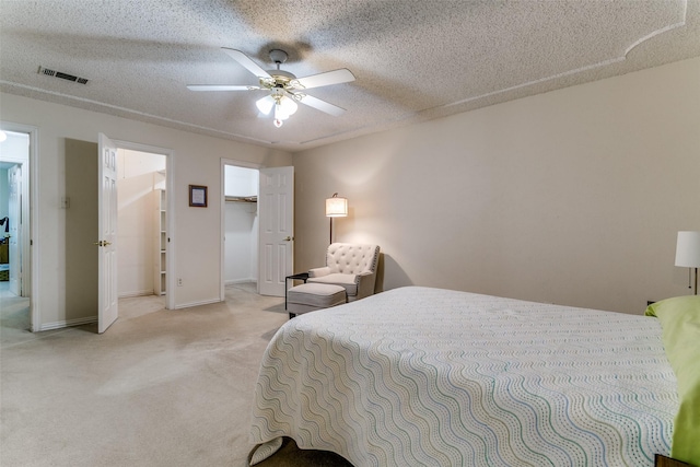 5312 Vermillion Trl, Arlington, TX 76017 - bedroom with light colored carpet, ceiling fan, a walk in closet, and a textured ceiling