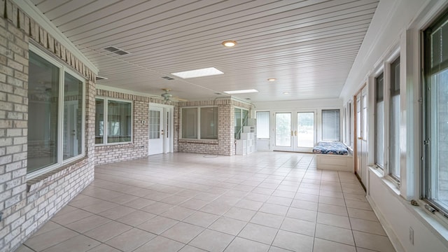 111 Scenic Dr, Dublin, TX 76446 - unfurnished sunroom featuring french doors, brick wall, tile patterned floors, and a skylight