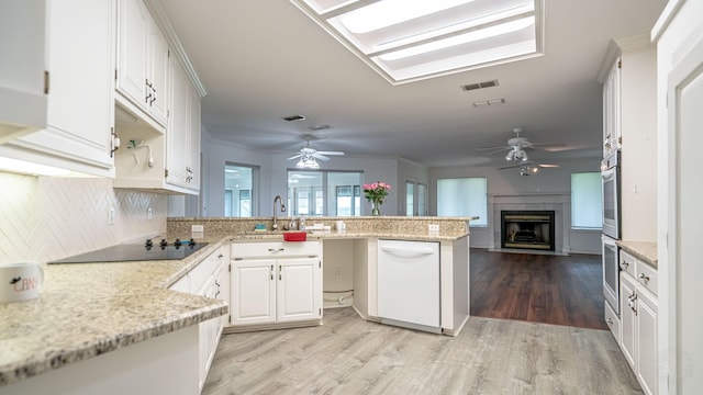 111 Scenic Dr, Dublin, TX 76446 - kitchen featuring ceiling fan, a peninsula, white dishwasher, black electric stovetop, and tasteful backsplash