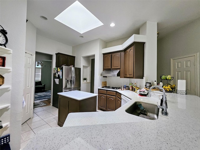 1412 Meadow Dr, Irving, TX 75063 - kitchen with a skylight, under cabinet range hood, stainless steel fridge with ice dispenser, dark brown cabinetry, and a kitchen island