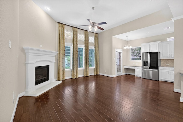 421 Fenceline Dr, Argyle, TX 76226 - unfurnished living room featuring ceiling fan, dark wood-style flooring, a fireplace, and a chandelier