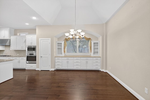 421 Fenceline Dr, Argyle, TX 76226 - kitchen with stainless steel appliances, a chandelier, under cabinet range hood, white cabinets, and dark wood-style flooring
