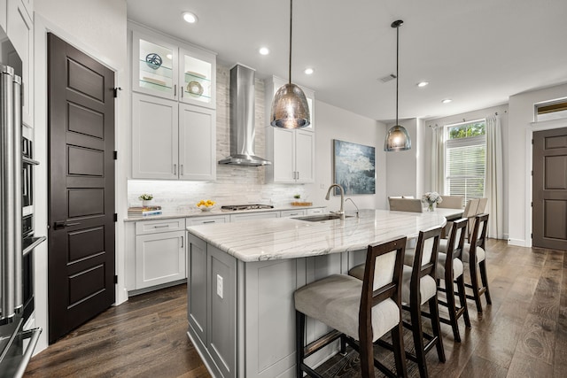 5495 Ashby Grove St, Dallas, TX 75209 - kitchen with wall chimney range hood, stainless steel gas stovetop, dark wood finished floors, white cabinets, and backsplash