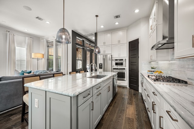 5495 Ashby Grove St, Dallas, TX 75209 - kitchen featuring appliances with stainless steel finishes, wall chimney range hood, backsplash, dark wood-type flooring, and recessed lighting