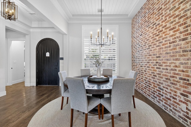 3387 Bellcrest Way, Celina, TX 75009 - dining room featuring a chandelier, arched walkways, wood finished floors, a tray ceiling, and brick wall