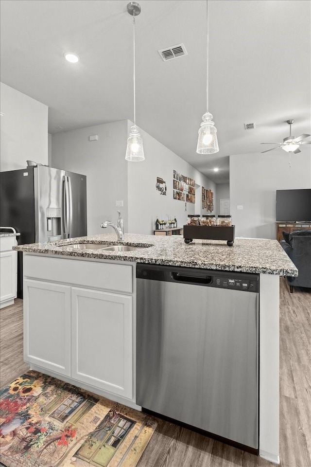 7118 Pampas Pl, Grand Prairie, TX 76804 - kitchen with appliances with stainless steel finishes, open floor plan, a ceiling fan, white cabinets, and light wood-style floors