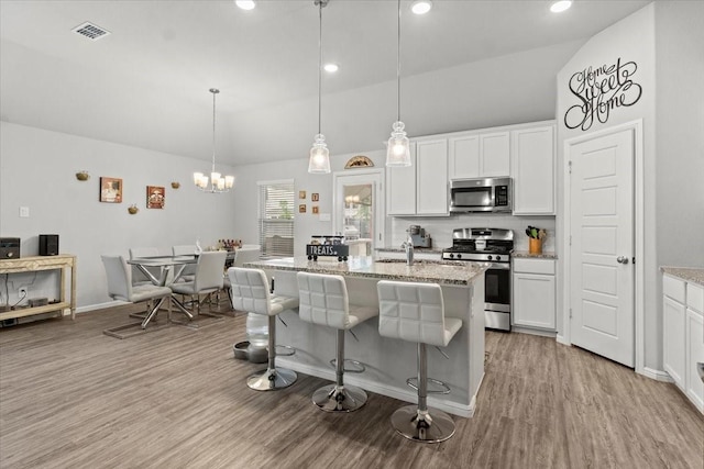 7118 Pampas Pl, Grand Prairie, TX 76804 - kitchen with appliances with stainless steel finishes, white cabinets, wood finished floors, recessed lighting, and high vaulted ceiling