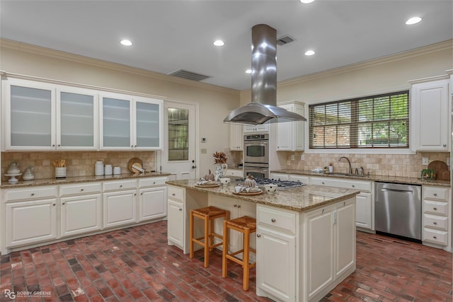 1078 Waters Edge Cir, Shreveport, LA 71106 - kitchen featuring stainless steel appliances, crown molding, island range hood, a kitchen island, and brick floors