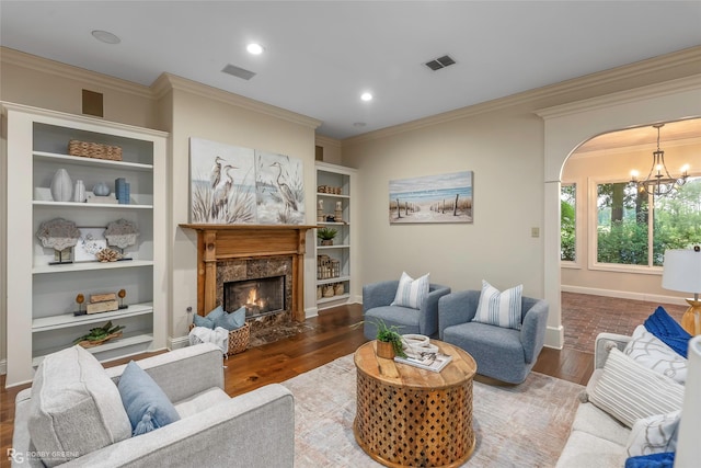 1078 Waters Edge Cir, Shreveport, LA 71106 - living room featuring a chandelier, wood finished floors, ornamental molding, arched walkways, and a high end fireplace