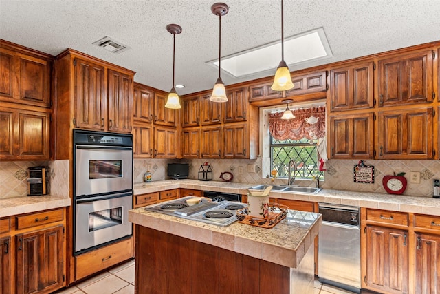 3503 Red Bud Dr, Weatherford, TX 76087 - kitchen with appliances with stainless steel finishes, light countertops, backsplash, light tile patterned floors, and hanging light fixtures