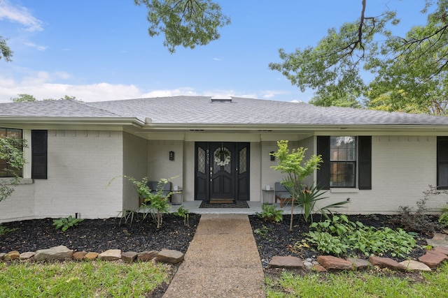 9735 Trevor Dr, Dallas, TX 75243 - entrance to property with brick siding, roof with shingles, and covered porch