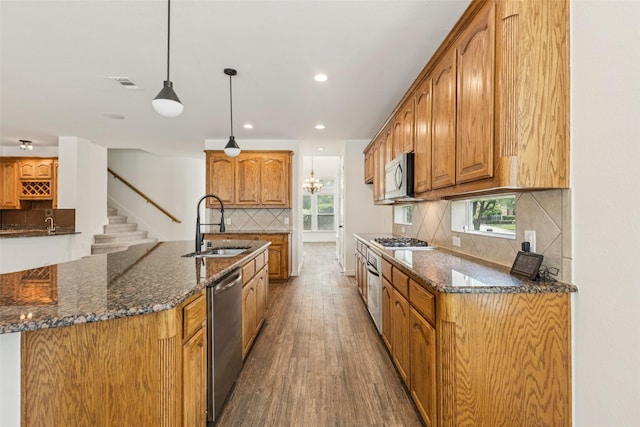 3442 Overhill Dr, Frisco, TX 75033 - kitchen with stainless steel appliances, dark wood-style flooring, decorative backsplash, dark stone counters, and recessed lighting
