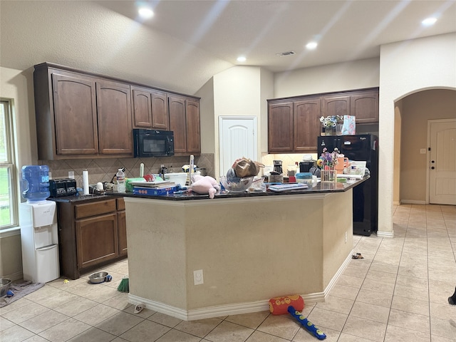 124 Brady Coleman Ln, Springtown, TX 76082 - kitchen with black appliances, arched walkways, dark countertops, backsplash, and light tile patterned flooring