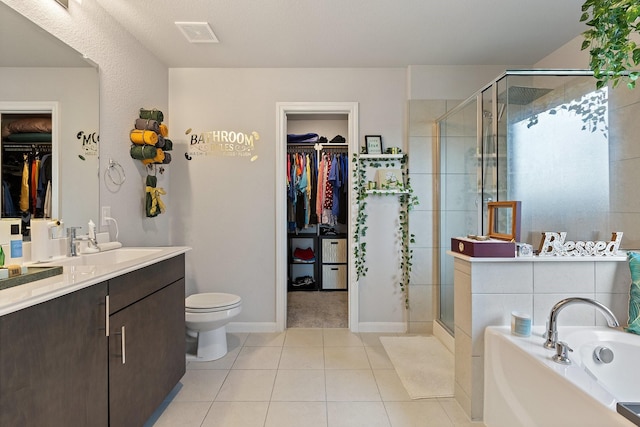 521 Bermuda Ave, Lancaster, TX 75146 - bathroom with a walk in closet, vanity, a shower stall, a garden tub, and tile patterned flooring