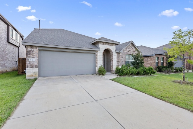 521 Bermuda Ave, Lancaster, TX 75146 - view of front facade featuring an attached garage, stone siding, driveway, a front yard, and a shingled roof