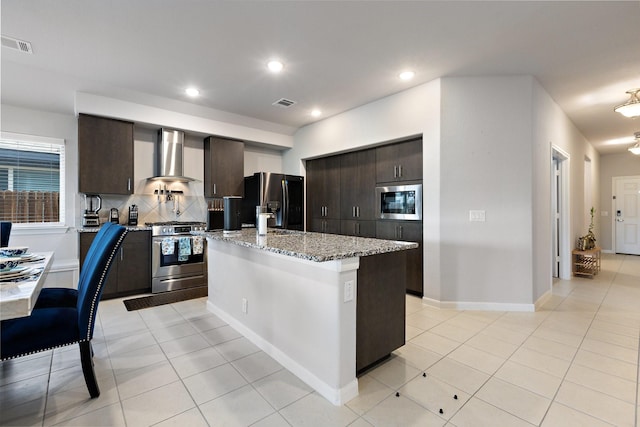 521 Bermuda Ave, Lancaster, TX 75146 - kitchen with stainless steel appliances, wall chimney exhaust hood, dark brown cabinets, a center island, and recessed lighting