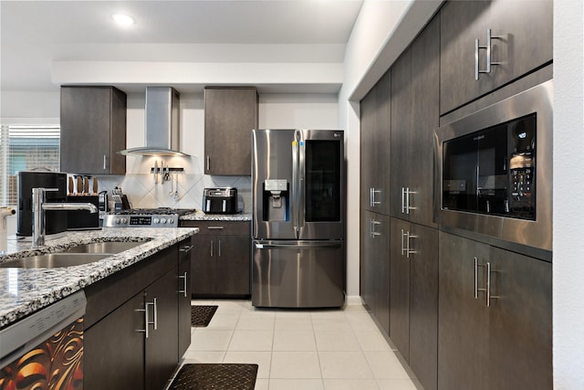 521 Bermuda Ave, Lancaster, TX 75146 - kitchen with stainless steel appliances, wall chimney range hood, light tile patterned flooring, dark brown cabinetry, and decorative backsplash