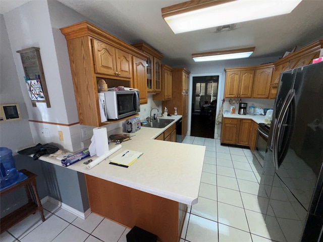 2720 Dorothy Dr, Keene, TX 76031 - kitchen featuring freestanding refrigerator, a peninsula, brown cabinetry, and light countertops