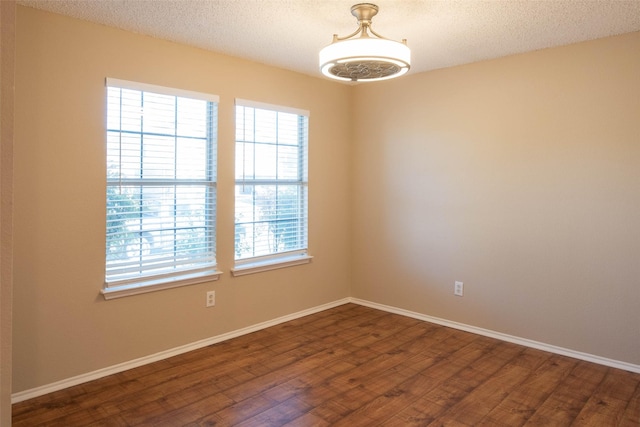 1565 Laurel Hall Ln, Little Elm, TX 75068 - unfurnished room with plenty of natural light, dark wood finished floors, and a textured ceiling