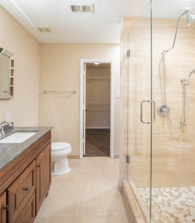 1565 Laurel Hall Ln, Little Elm, TX 75068 - bathroom with a shower stall, vanity, tile patterned floors, a spacious closet, and a textured ceiling