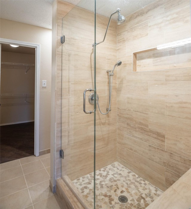 1565 Laurel Hall Ln, Little Elm, TX 75068 - bathroom featuring a stall shower, tile patterned floors, a textured ceiling, and a walk in closet