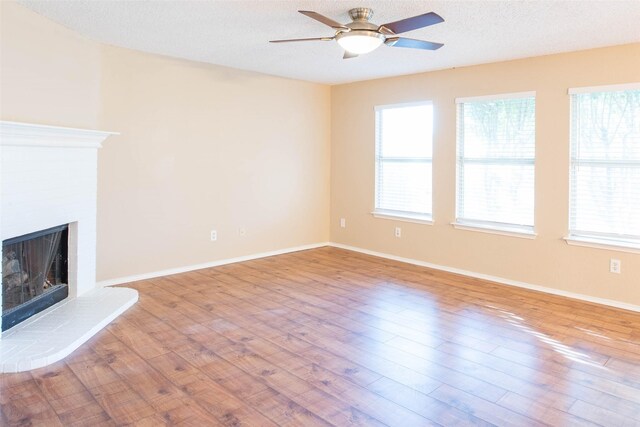 1565 Laurel Hall Ln, Little Elm, TX 75068 - unfurnished living room with a ceiling fan, wood finished floors, and a brick fireplace