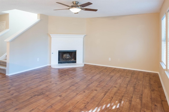 1565 Laurel Hall Ln, Little Elm, TX 75068 - unfurnished living room featuring ceiling fan, stairs, wood finished floors, and a fireplace