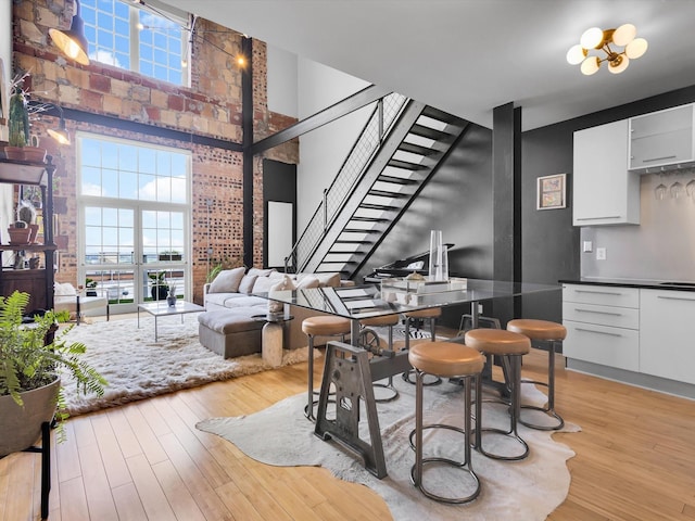 1122 Jackson St Unit 1103, Dallas, TX 75202 - dining area with light wood-style floors, a towering ceiling, stairs, and healthy amount of natural light