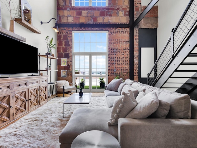 1122 Jackson St Unit 1103, Dallas, TX 75202 - living area featuring a high ceiling, brick wall, and stairs