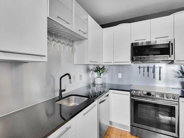 1122 Jackson St Unit 1103, Dallas, TX 75202 - kitchen with appliances with stainless steel finishes, white cabinets, and dark stone countertops