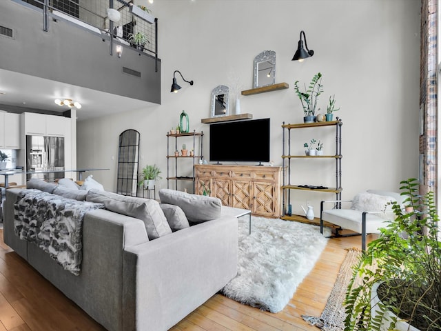 1122 Jackson St Unit 1103, Dallas, TX 75202 - living room featuring hardwood / wood-style floors and a towering ceiling