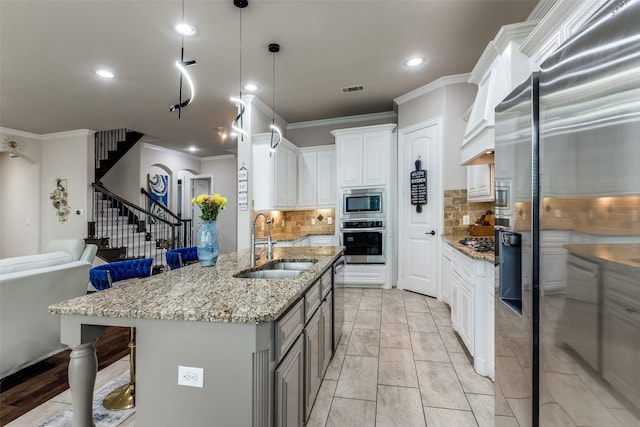751 Devonshire Ct, Prosper, TX 75078 - kitchen with appliances with stainless steel finishes, crown molding, backsplash, light stone counters, and white cabinetry