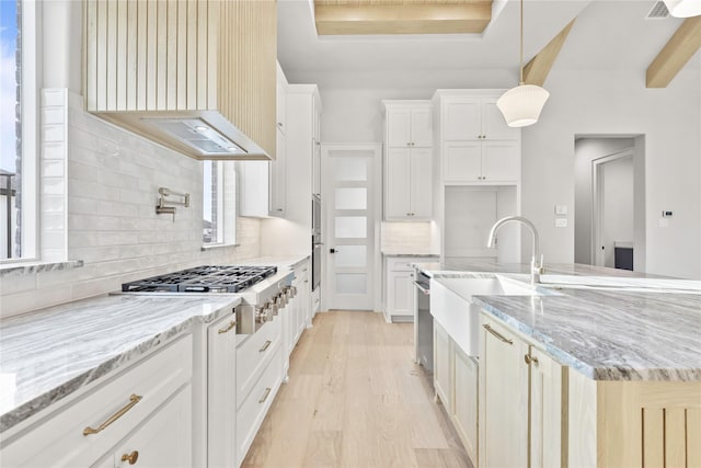 232 Bel Grand Rd, Haslet, TX 76052 - kitchen featuring appliances with stainless steel finishes, light wood-type flooring, decorative backsplash, wall chimney range hood, and light stone countertops