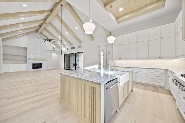 232 Bel Grand Rd, Haslet, TX 76052 - kitchen with stainless steel dishwasher, light wood-style floors, a large fireplace, a center island with sink, and beamed ceiling