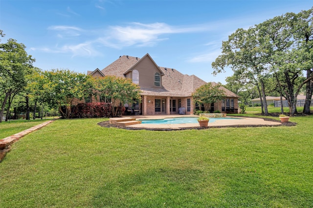 5101 Oak Timbers Ct, Colleyville, TX 76034 - back of house featuring brick siding, a yard, and a pool with connected hot tub