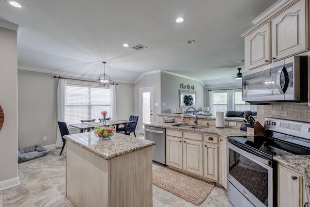 785 Crockett Dr, Lavon, TX 75166 - kitchen with appliances with stainless steel finishes, ornamental molding, a peninsula, cream cabinetry, and light stone countertops