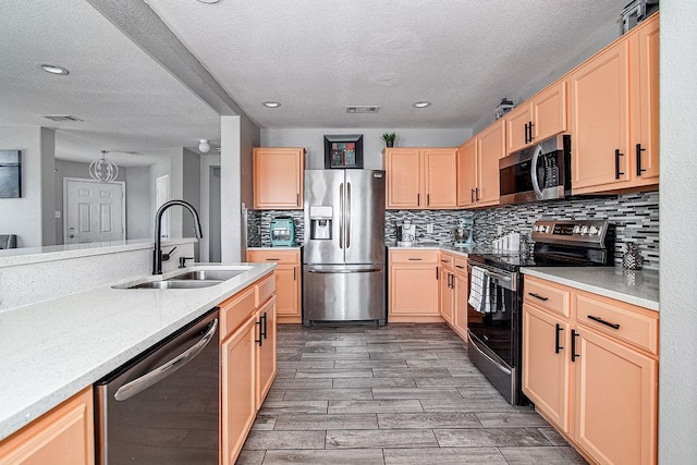 7400 Howling Coyote Ln, Fort Worth, TX 76131 - kitchen featuring appliances with stainless steel finishes, light brown cabinetry, light countertops, a textured ceiling, and tasteful backsplash