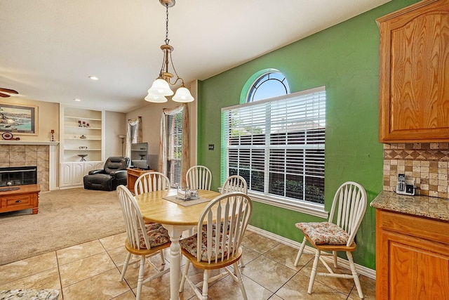 9513 Tiger Dr, Plano, TX 75025 - dining room with light tile patterned flooring, light carpet, a tile fireplace, built in shelves, and recessed lighting