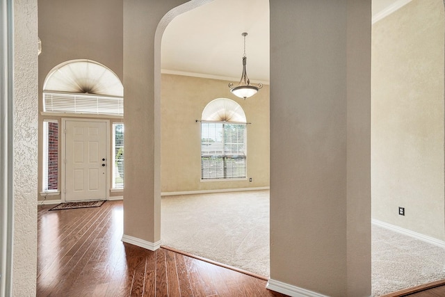 9513 Tiger Dr, Plano, TX 75025 - foyer with crown molding, wood finished floors, arched walkways, and carpet floors