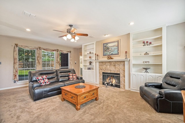 9513 Tiger Dr, Plano, TX 75025 - living area featuring ceiling fan, carpet, a tiled fireplace, built in features, and recessed lighting