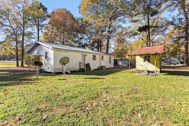 1054 Frontage Rd, Minden, LA 71055 - rear view of house with a metal roof, a lawn, entry steps, and an outbuilding