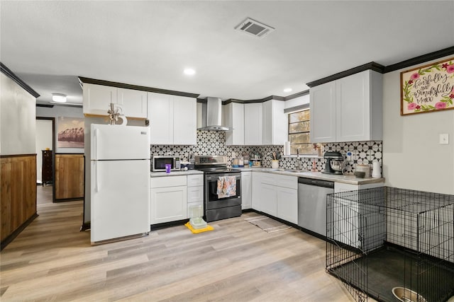 1054 Frontage Rd, Minden, LA 71055 - kitchen with stainless steel appliances, wall chimney exhaust hood, light wood finished floors, white cabinets, and crown molding