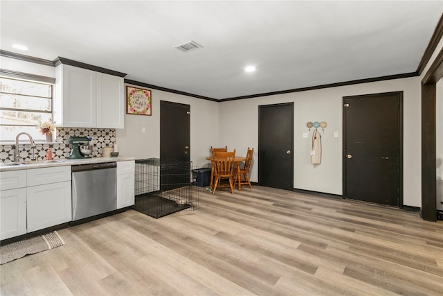 1054 Frontage Rd, Minden, LA 71055 - kitchen with stainless steel dishwasher, light wood-type flooring, crown molding, light countertops, and white cabinetry