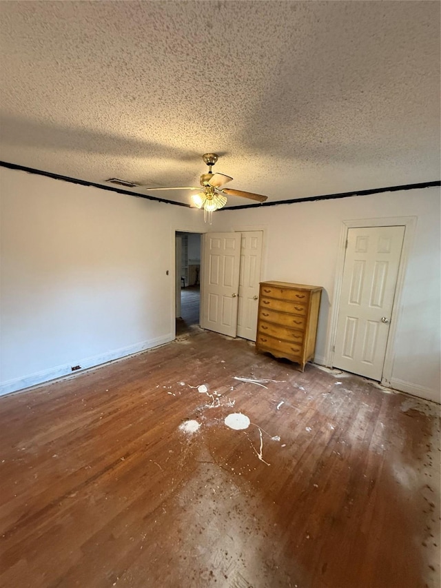 709 Highland Dr, Palestine, TX 75801 - unfurnished bedroom featuring a textured ceiling, hardwood / wood-style floors, and a ceiling fan