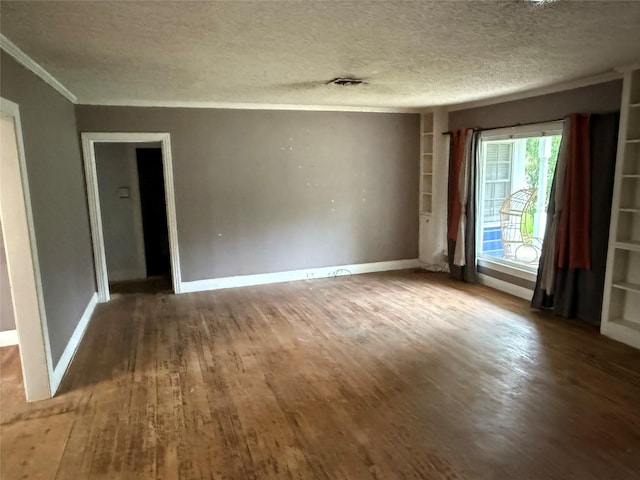 709 Highland Dr, Palestine, TX 75801 - spare room with wood finished floors, a textured ceiling, ornamental molding, and built in shelves