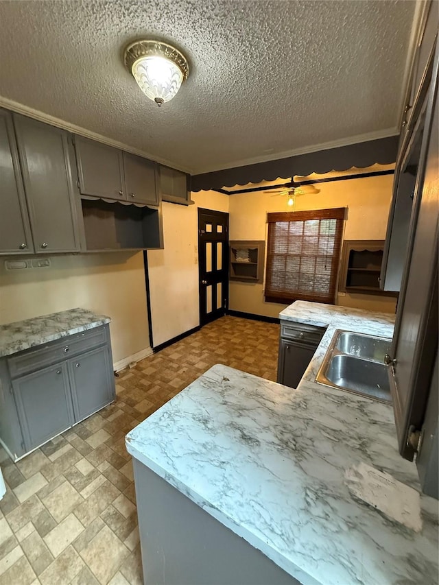 709 Highland Dr, Palestine, TX 75801 - kitchen with gray cabinets, a textured ceiling, light countertops, and a peninsula