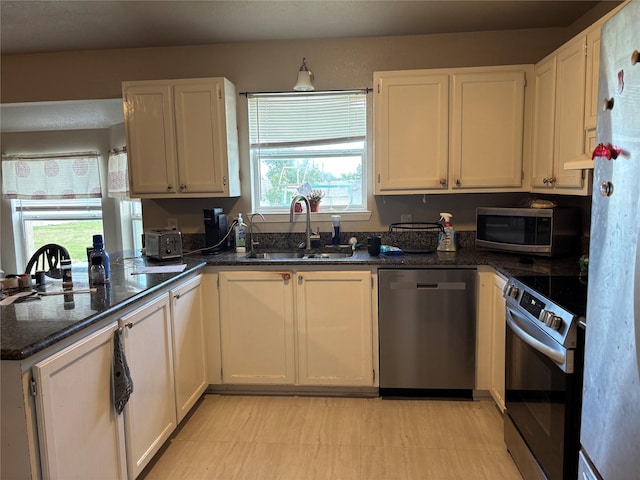 4052 Country Meadows Cir, Granbury, TX 76049 - kitchen featuring stainless steel appliances, a peninsula, dark stone countertops, white cabinets, and light floors