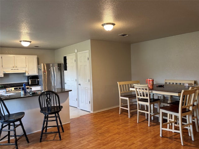 4052 Country Meadows Cir, Granbury, TX 76049 - dining space featuring a textured ceiling and light wood-style floors